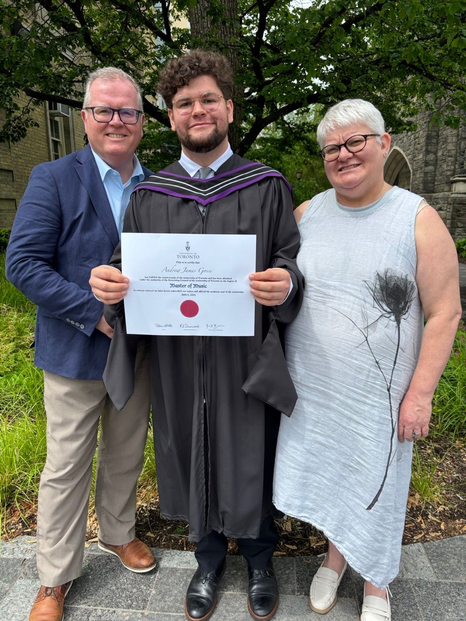 myself holding university degree in middle of photograph with one smiling person on either side